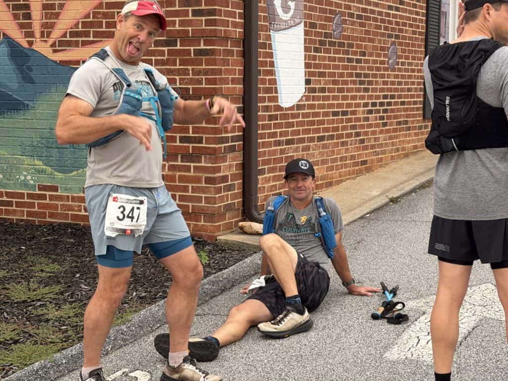 Two men resting after a fall race in Franklin, smiling and relaxed.