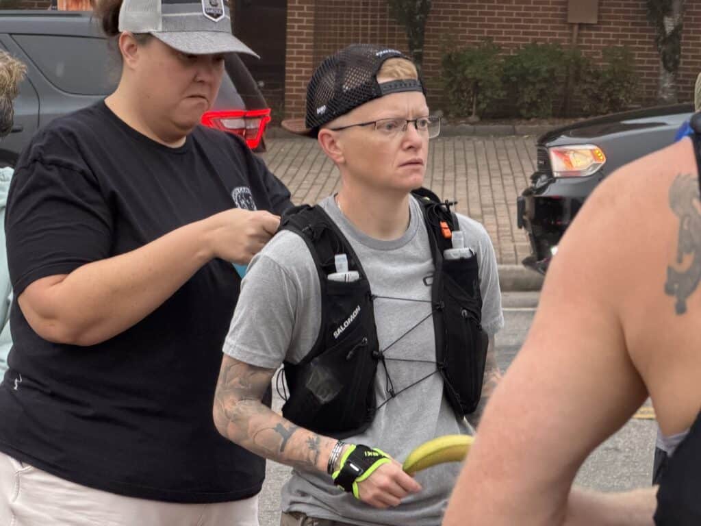 Young woman with tattoos and backpack at fall event in Franklin.