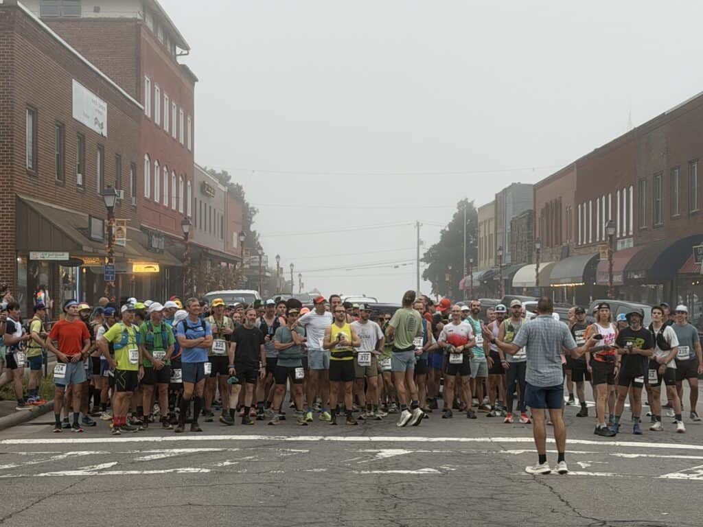 Large group of runners at the start line in Franklin during fall festival.