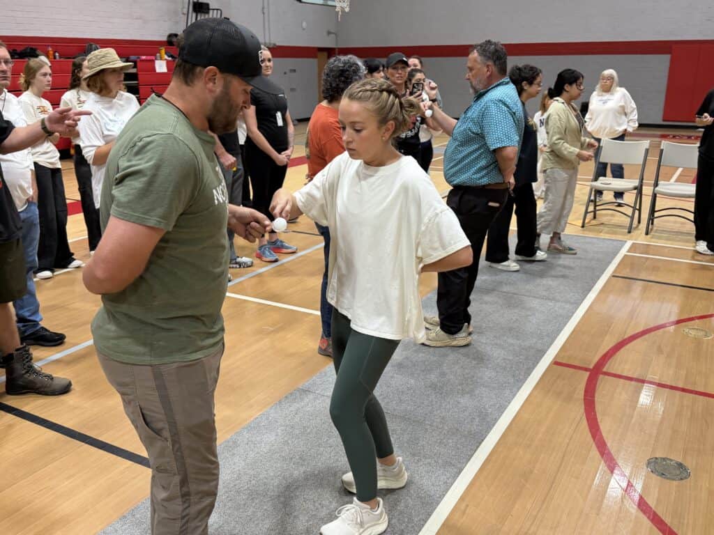Children and adults enjoying a fall event in a gymnasium.