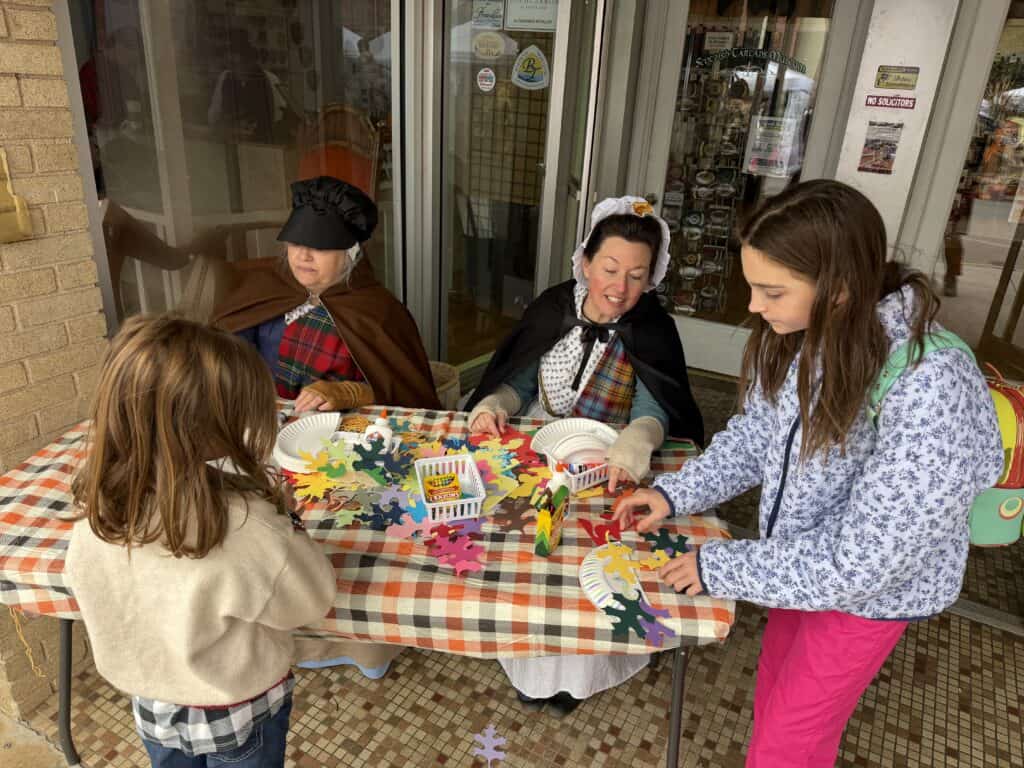 Family crafting fall decorations at outdoor table in Franklin.