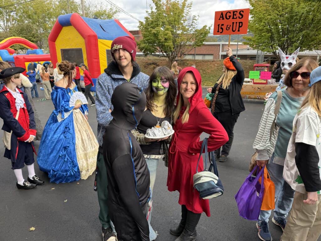 People dressed in costumes at fall festival in Franklin with bounce house.