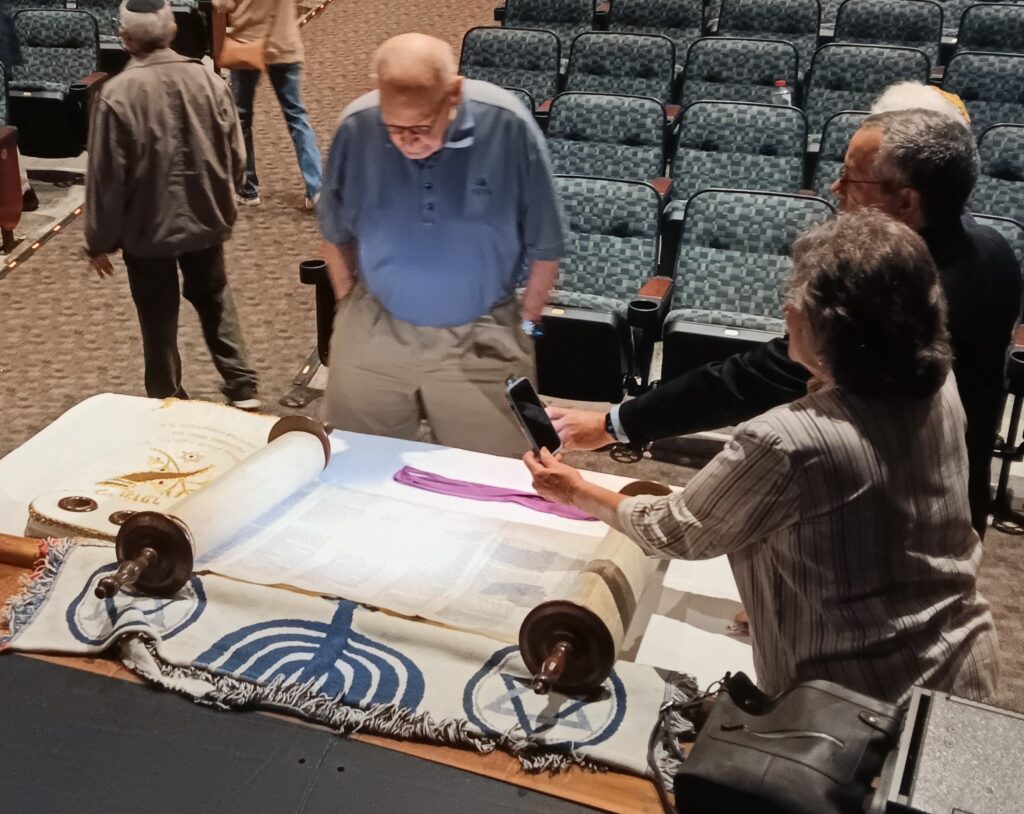 People discussing the Paper Clips Project at a table with scrolls and artifacts.