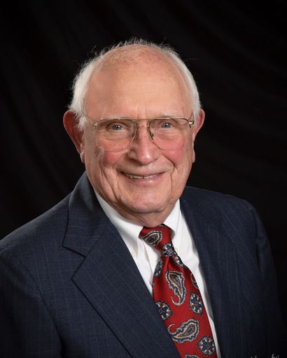 Portrait of James D. Schulte Sr., smiling, in a suit and tie.