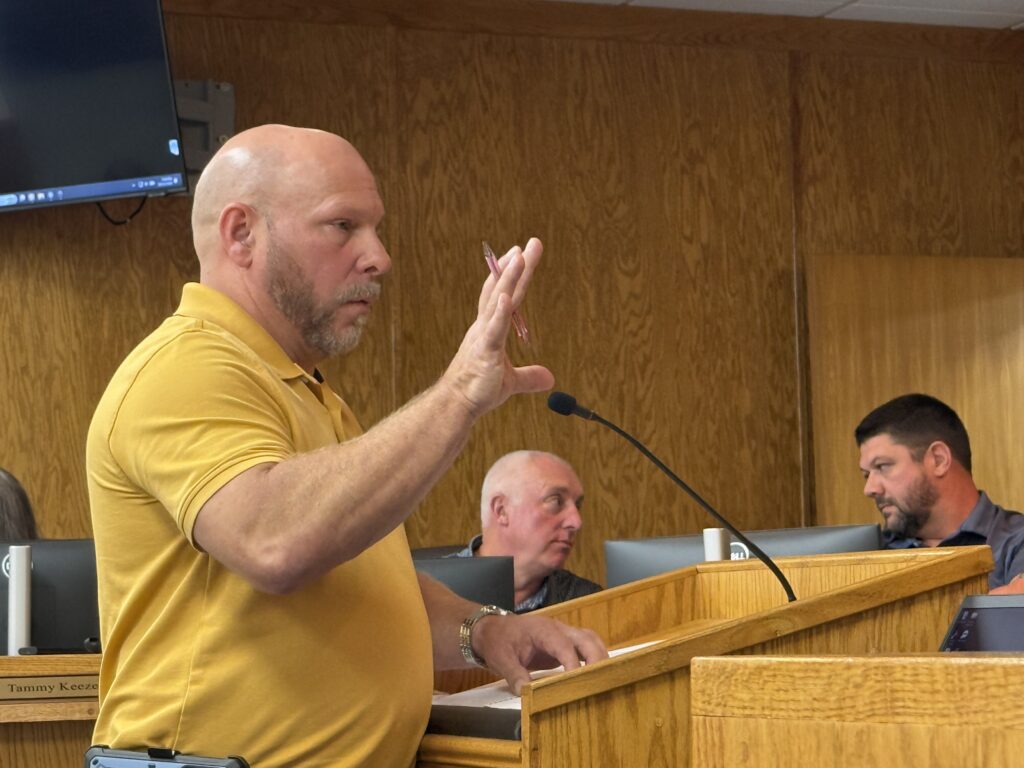 Man speaking at a public meeting about East Franklin school plans.