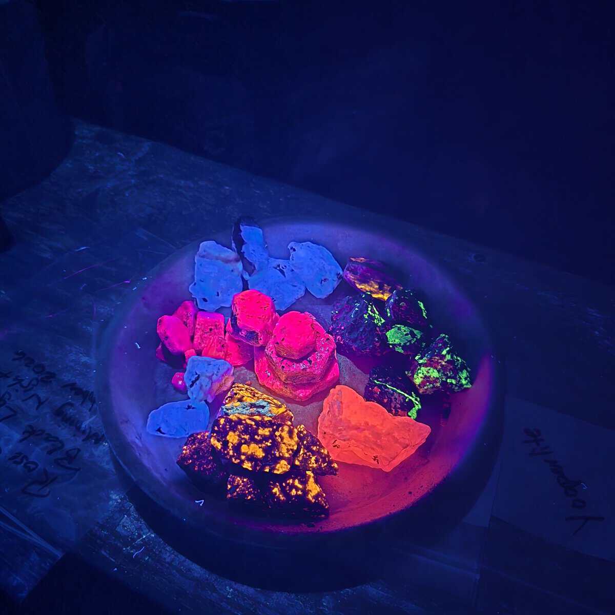 Vibrant glow-in-the-dark minerals under black light for mining display.